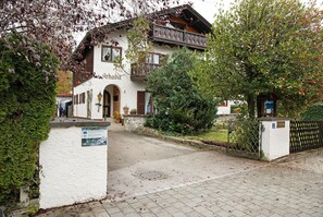 Ein traditionelles Gebäude mit Balkon, Steinmauer und einem Schild.