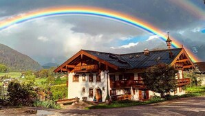 Un chalet traditionnel doté d’un toit à pente, de balcons en bois et de fondations en pierre.