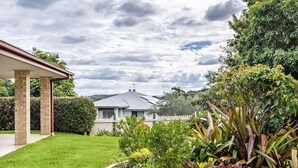 Un jardin bien entretenu, avec une grande variété de plantes et un patio couvert.