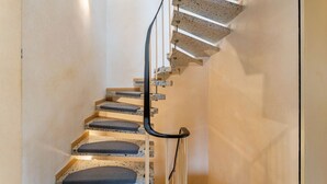 A spiral staircase with a handrail and steps. - Holiday Home 'Haus Waldblick' with Private Terrace, Private Garden and Wi-Fi (Bad Berleburg)