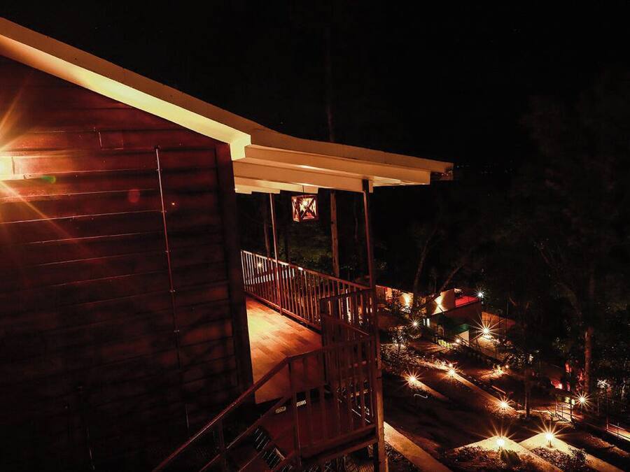 En træbygning med en overdækket balkon om natten.