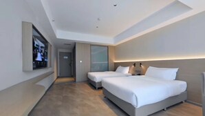 A modern hotel room with two beds, a large mirror, and a TV on the wall. - Wassim Hotel Fushun Yantan (Zigong)