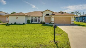 A single-story house with a garage, a front yard, and a mailbox. - Port Charlotte Home ~ 3 Mi to Beach & Harbor! (Port Charlotte)