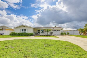 A two-story house with a front yard, driveway, and a clear sky with clouds. - Private Fishing Dock: Waterfront Palmetto Home! (Palmetto)