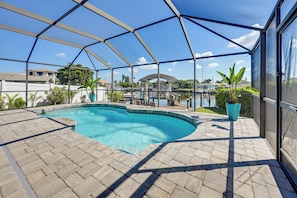 A covered swimming pool with a clear view of the surrounding area, including a boat dock and buildings. - Private Fishing Dock: Waterfront Palmetto Home! (Palmetto)