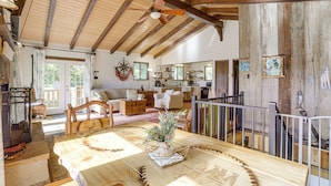 A spacious living area with a wooden ceiling, a dining table with a centerpiece, and a kitchen in the background. - Breathtaking Lake Views | Walk to Alpine Lake (Terra Alta)