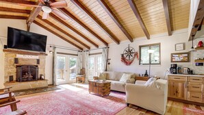 A spacious living room with a fireplace, wooden beams, a television, and a cozy seating area. - Breathtaking Lake Views | Walk to Alpine Lake (Terra Alta)