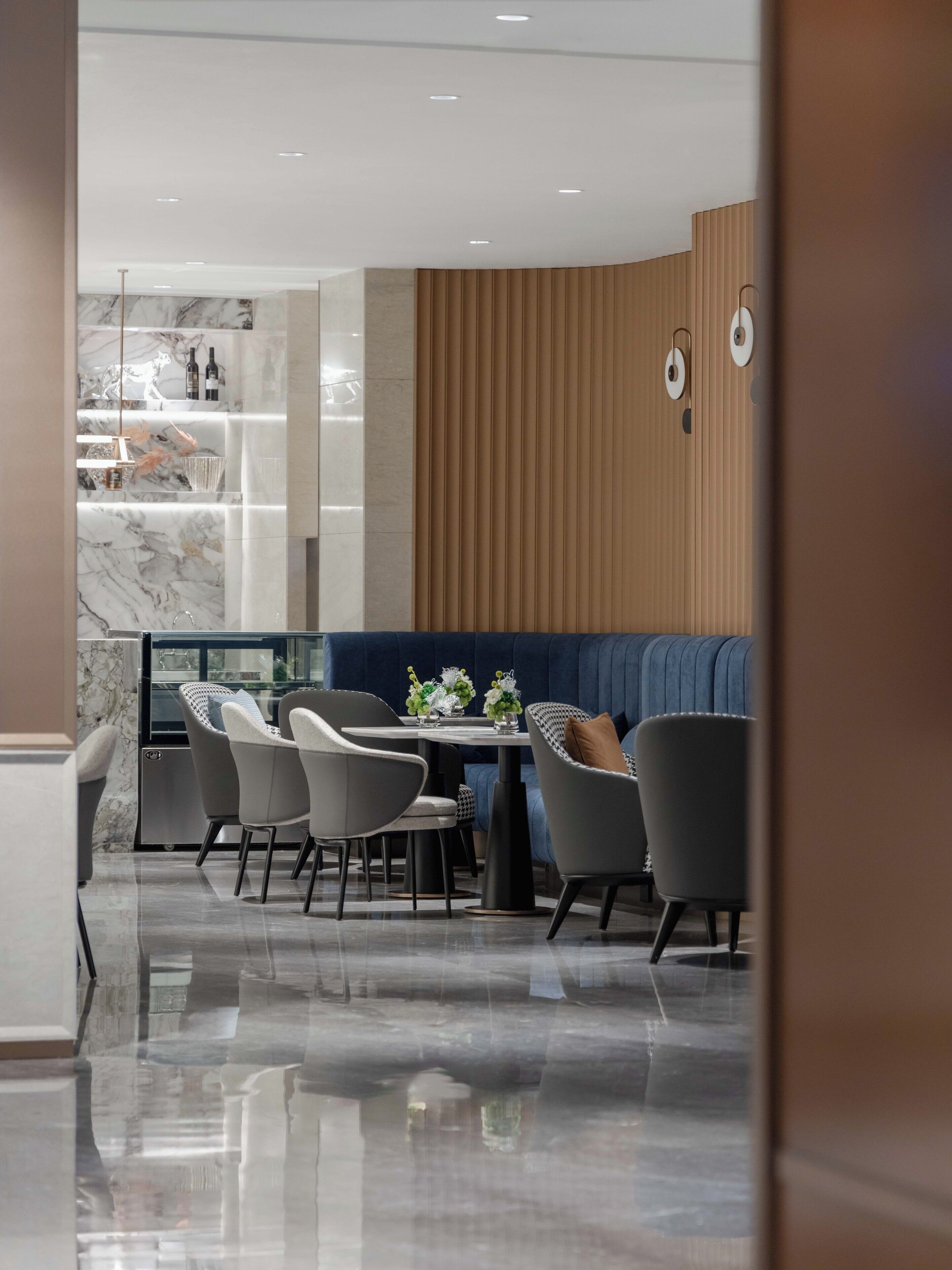 A modern dining area with a marble countertop, a round table, and contemporary chairs.