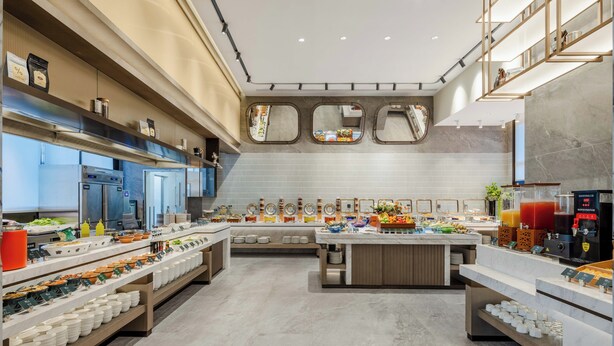 A modern kitchen with a central island, built-in appliances, and a variety of food items displayed on shelves. - Grand Madison LongHua Yujing Shenzhen (Shenzhen)