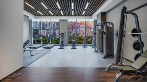A modern gym with exercise equipment, large windows, and a city view. - Grand Madison LongHua Yujing Shenzhen (Shenzhen)