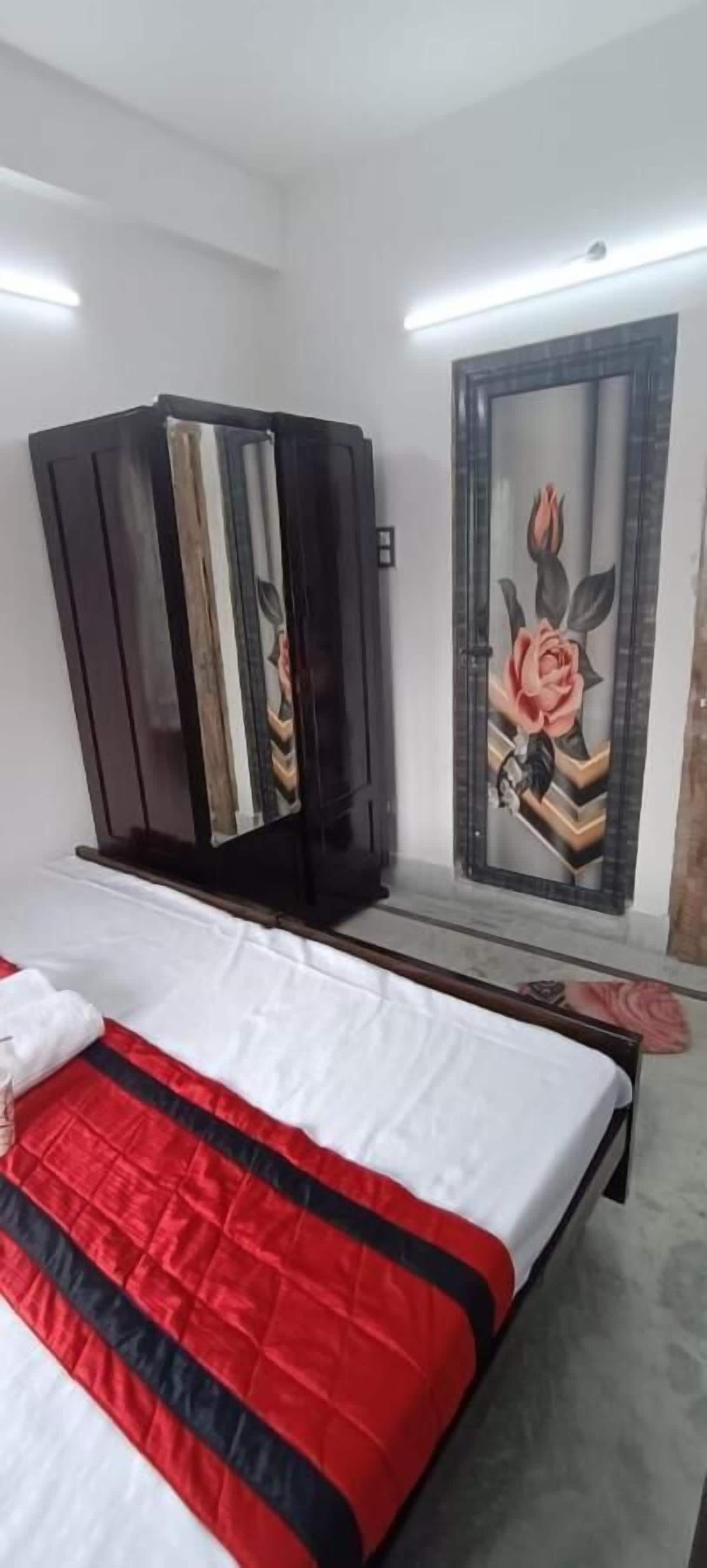Une chambre à coucher comprenant un lit, une armoire et un miroir fixé au mur.