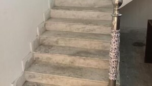A staircase with a metal handrail and a red mat at the bottom. - Regencyy Guest House (Kolkata)