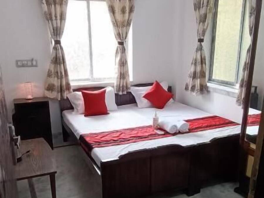 A bedroom with a bed, curtains, a ceiling fan, and a window.