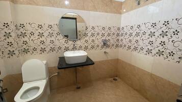 A bathroom with a toilet, sink, and mirror.