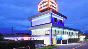 A hotel with a neon sign, a modern facade, and a sign indicating a price of 3,500 yen per night. - Hotel St.River - Adult only (Toyama)