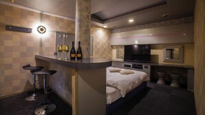 A modern hotel room with a bed, a small bar area, and a TV. - Hotel St.River - Adult only (Toyama)