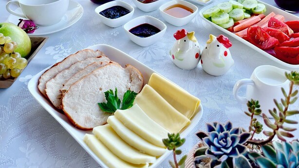Une table dressée pour le petit-déjeuner, avec divers aliments, et une vue panoramique en arrière-plan.