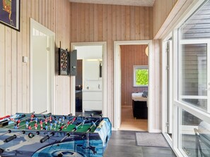 A room with a foosball table, a dartboard, and a mirror.