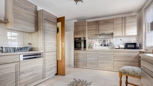 Una cocina moderna con armarios de madera, horno empotrado y microondas.