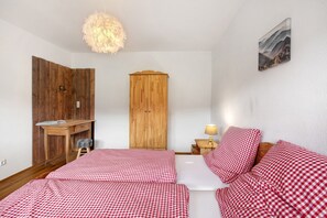 Une pièce comprenant un lit, une armoire en bois, un bureau et une lampe.