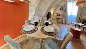 Comedor con una mesa redonda dispuesta para cuatro personas, rodeado de sillas acolchadas.