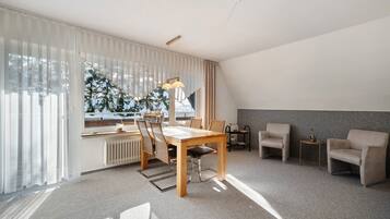 Ein modernes Wohnzimmer mit Esstisch, Stühlen, einer Couch und einer Heizung.