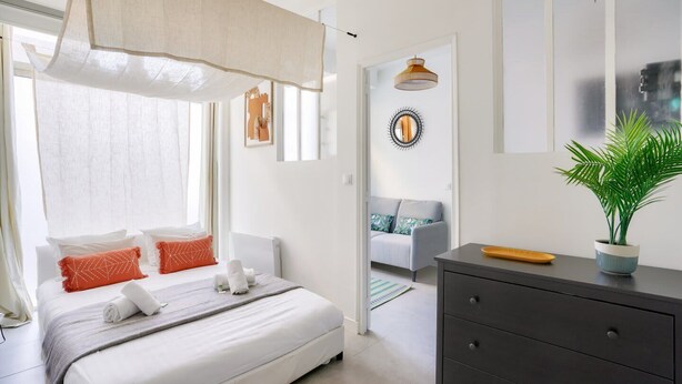 Un dormitorio moderno con cama, cómoda y planta en maceta.