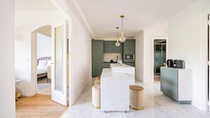 Une cuisine moderne avec des meubles blancs, un îlot central et un coin repas.