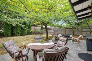 A patio area with a round table, chairs, and a sofa. - Spacious SW Portland 4BR/3BA | 2 King Suites | 15min to Downtown | Groups of 8 (Portland)