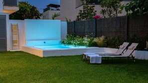 Un jardin avec une piscine, des chaises longues et une clôture en bois.