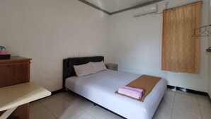 A bedroom with a bed, bedside table, and a wardrobe.