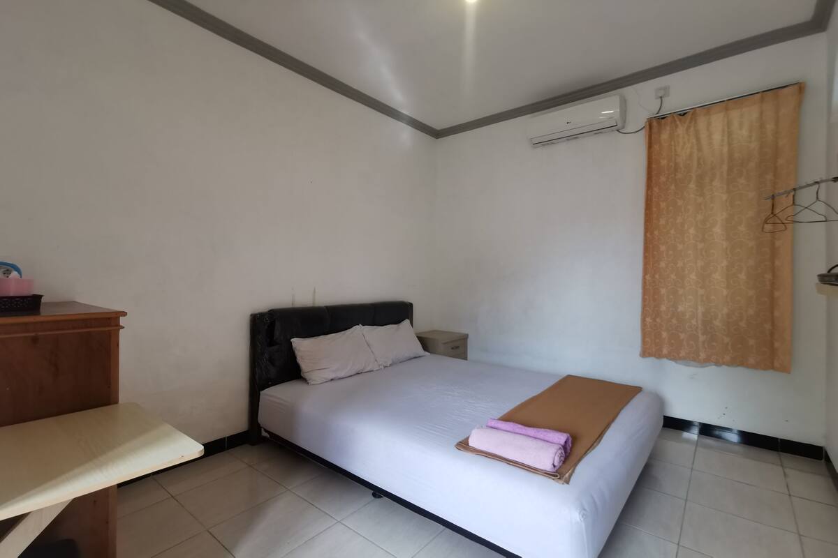 Ein Schlafzimmer mit Bett, Nachttisch und Kleiderschrank.