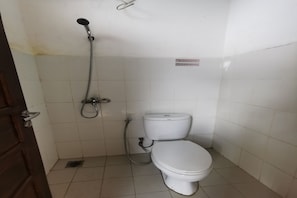 A small, clean bathroom with a toilet, a shower, and a handrail. - OYO 94061 Bungas Guesthouse Syariah (Samarinda)