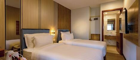Una habitación de hotel con dos camas, una mesita de noche de mármol y un armario de madera.