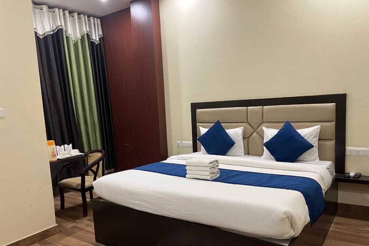 Una habitación de hotel con una cama grande, un escritorio y una silla.