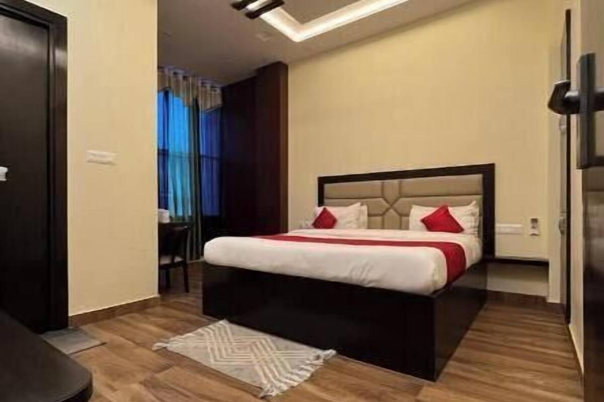 Un dormitorio moderno con cama, ventilador de techo y piso de madera.