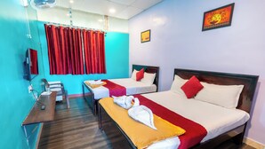 Une chambre d’hôtel avec deux lits, un bureau et une télévision.