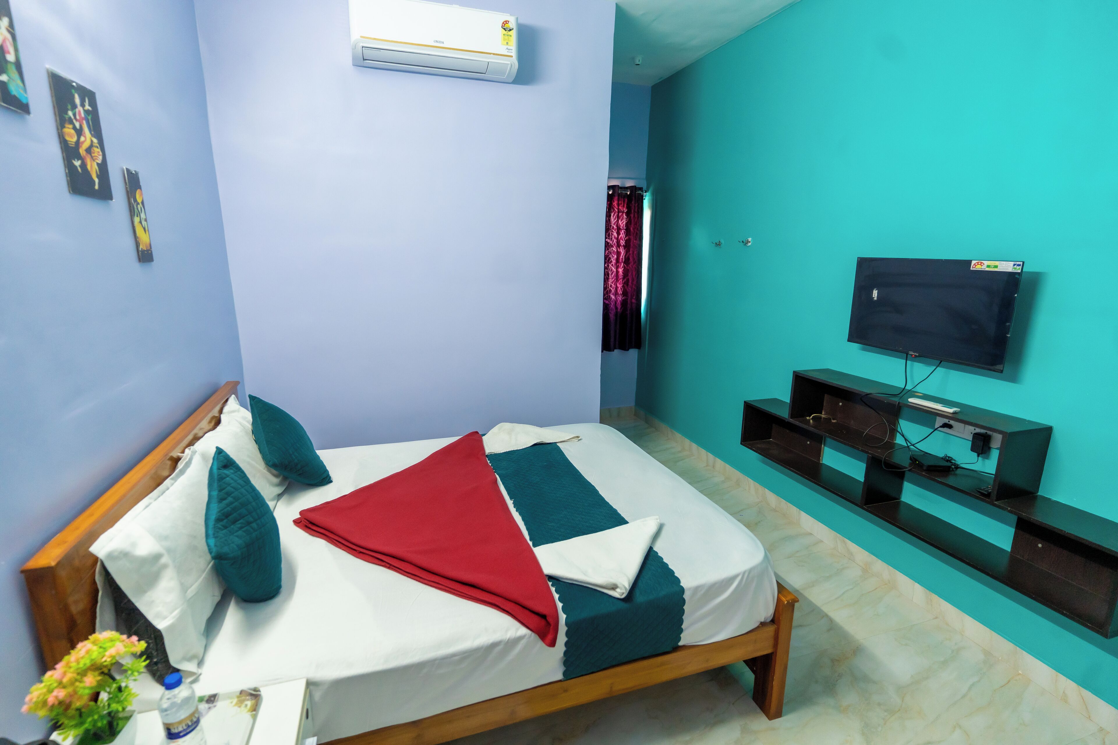 A bedroom with a bed, a TV, and a wall-mounted air conditioner.