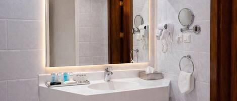 A modern bathroom with two sinks, a large mirror, and a hairdryer on the wall.