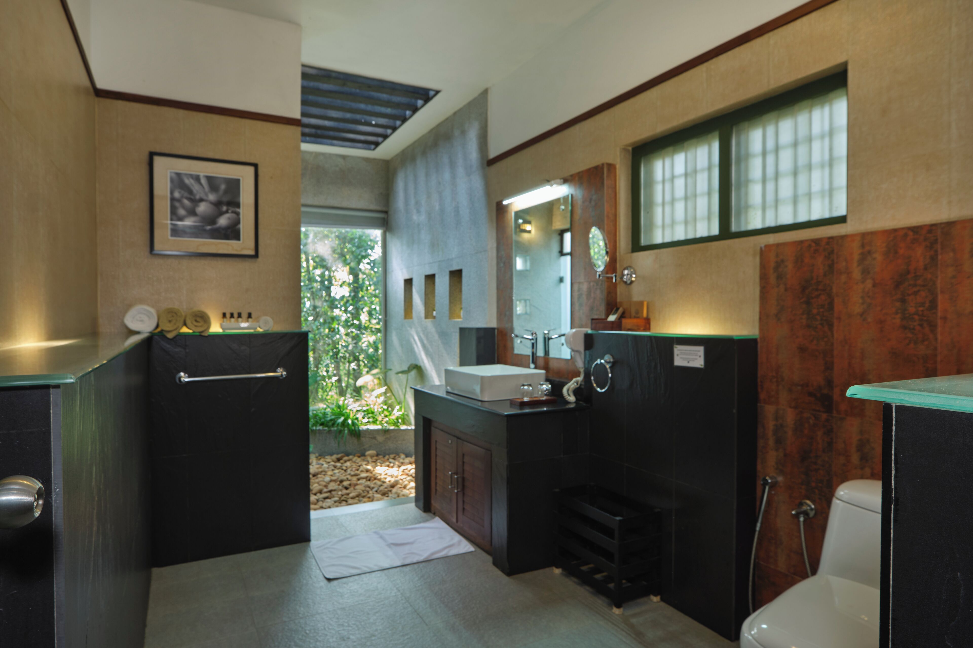 A compact bathroom with a sink, mirror, and toilet.