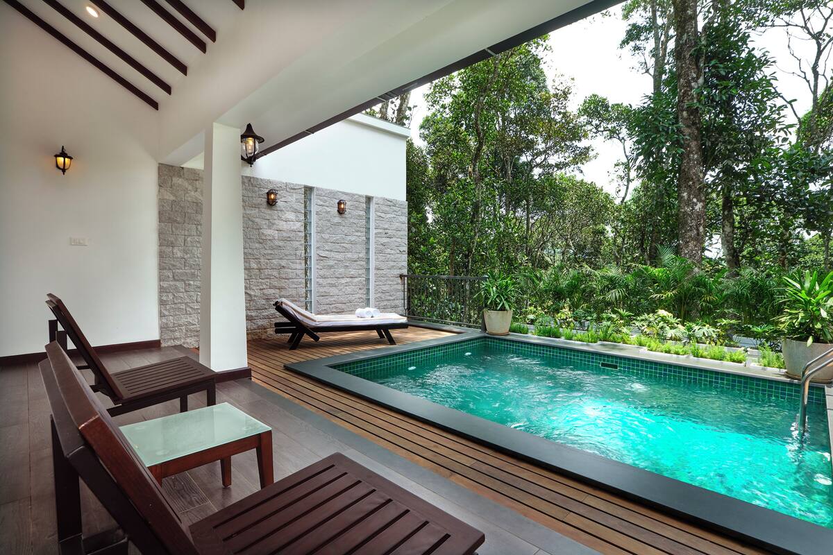 A modern outdoor pool area with wooden furniture and stone walls.