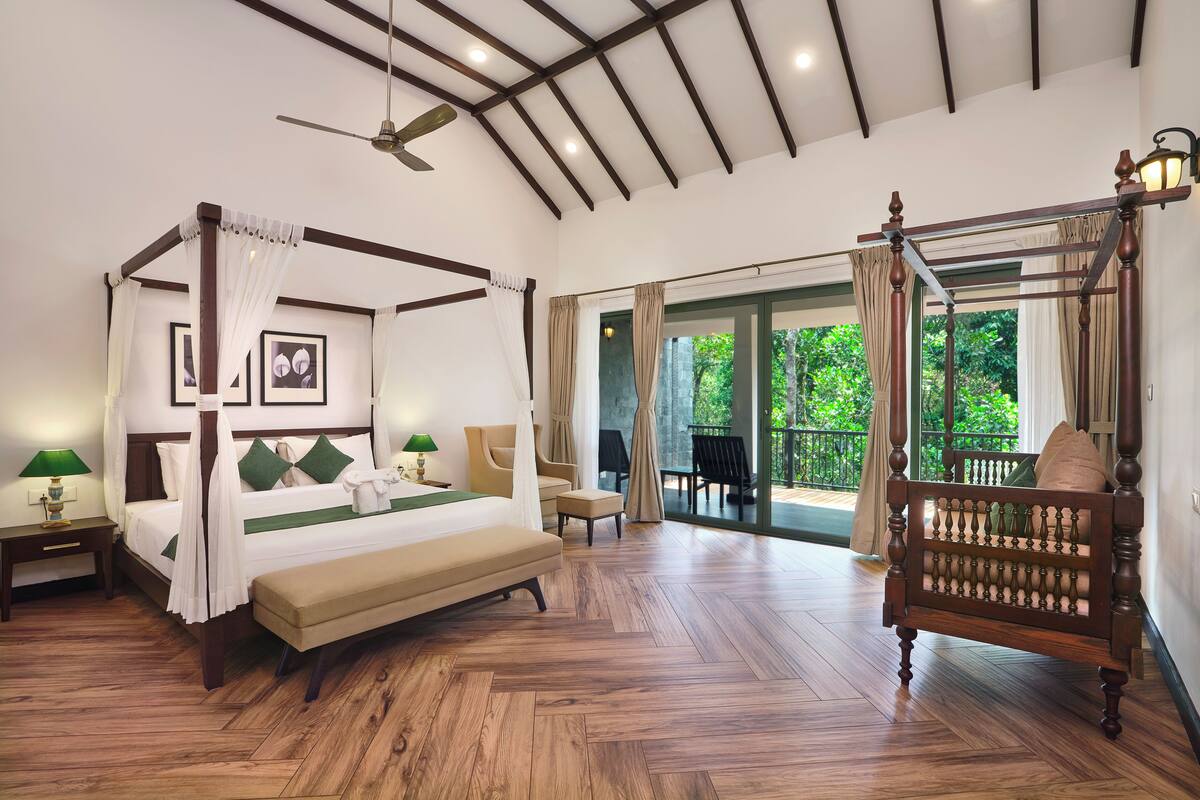 A four-poster bed with a canopy, a bench, and a balcony with outdoor seating.