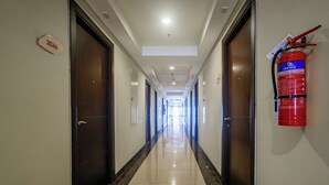 A hotel hallway with doors, a fire extinguisher, and a sign indicating room number 3516. - OYO 94064 Sayy Rooms At Springwood (Tangerang)