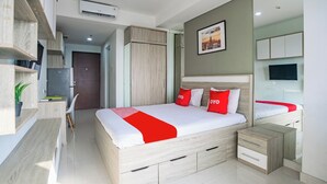 A modern bedroom with a large bed, bedside tables, a desk, and a mirror. - OYO 94064 Sayy Rooms At Springwood (Tangerang)