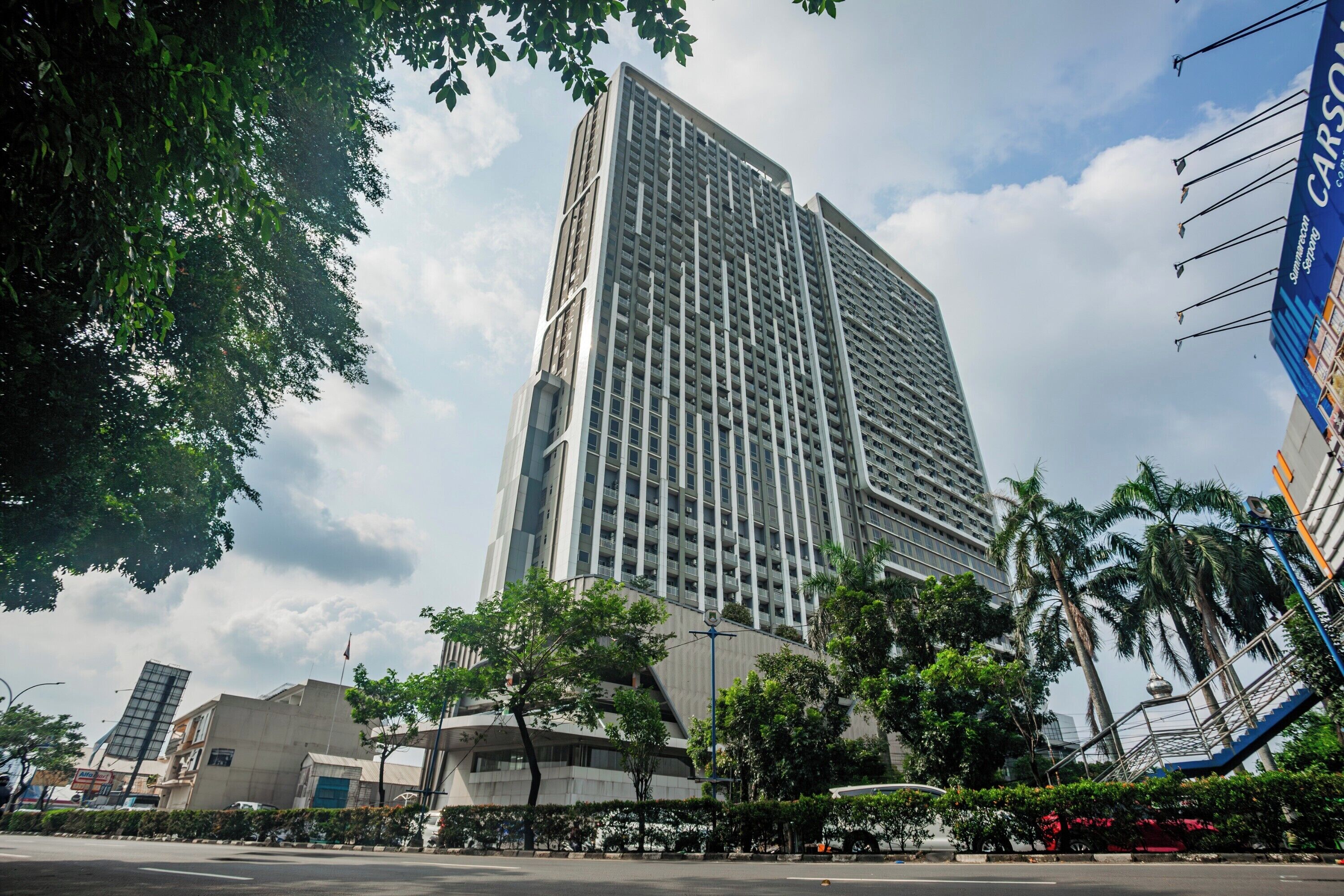 A tall, modern building with a grid-like facade and a prominent entrance.