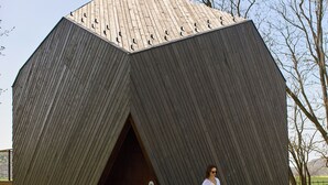 A large wooden structure with a hexagonal shape and a door. - Rock Cabins (Vigántpetend)