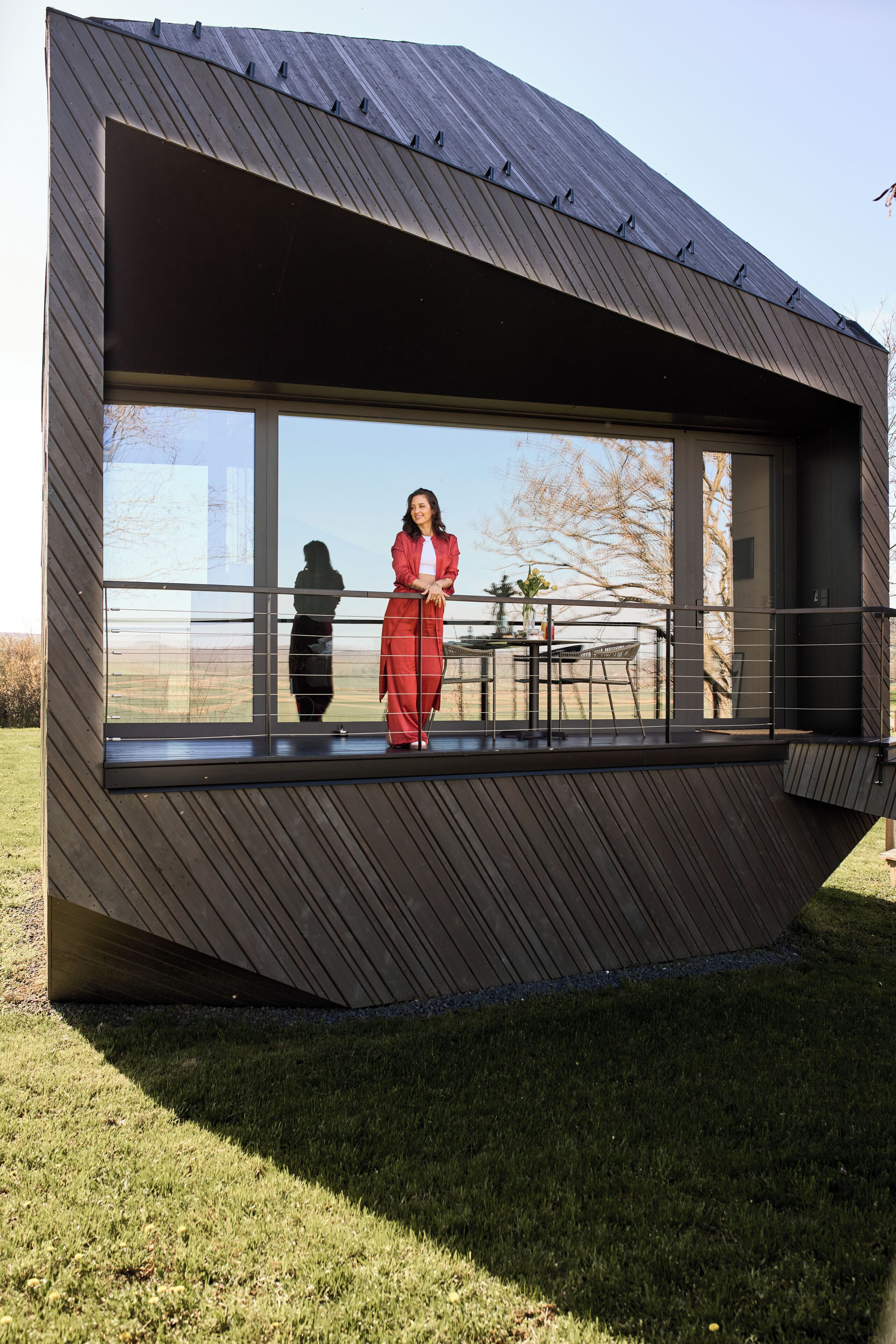 Un bâtiment moderne doté d’une grande baie vitrée et d’un balcon.
