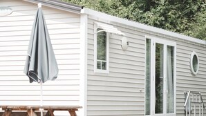 A mobile home with a picnic table and an umbrella. - Woodland Chalet in the Ardennes (Viroinval)