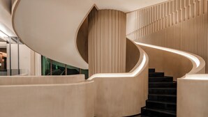 Een modern interieur met een gebogen trap, gepolijste vloeren en een minimalistisch design.