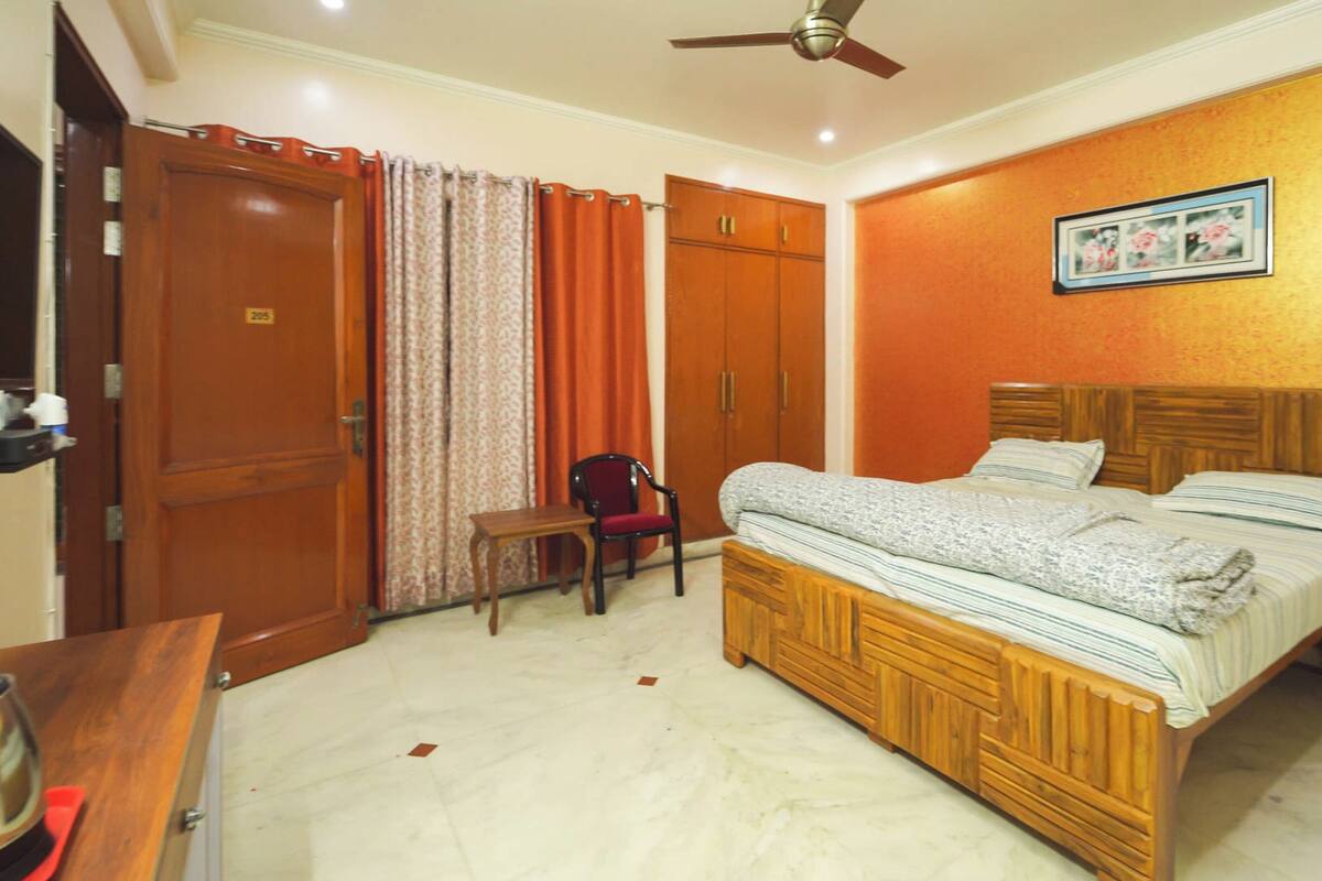 Une chambre à coucher comprenant un lit, une chaise, un bureau et une armoire.